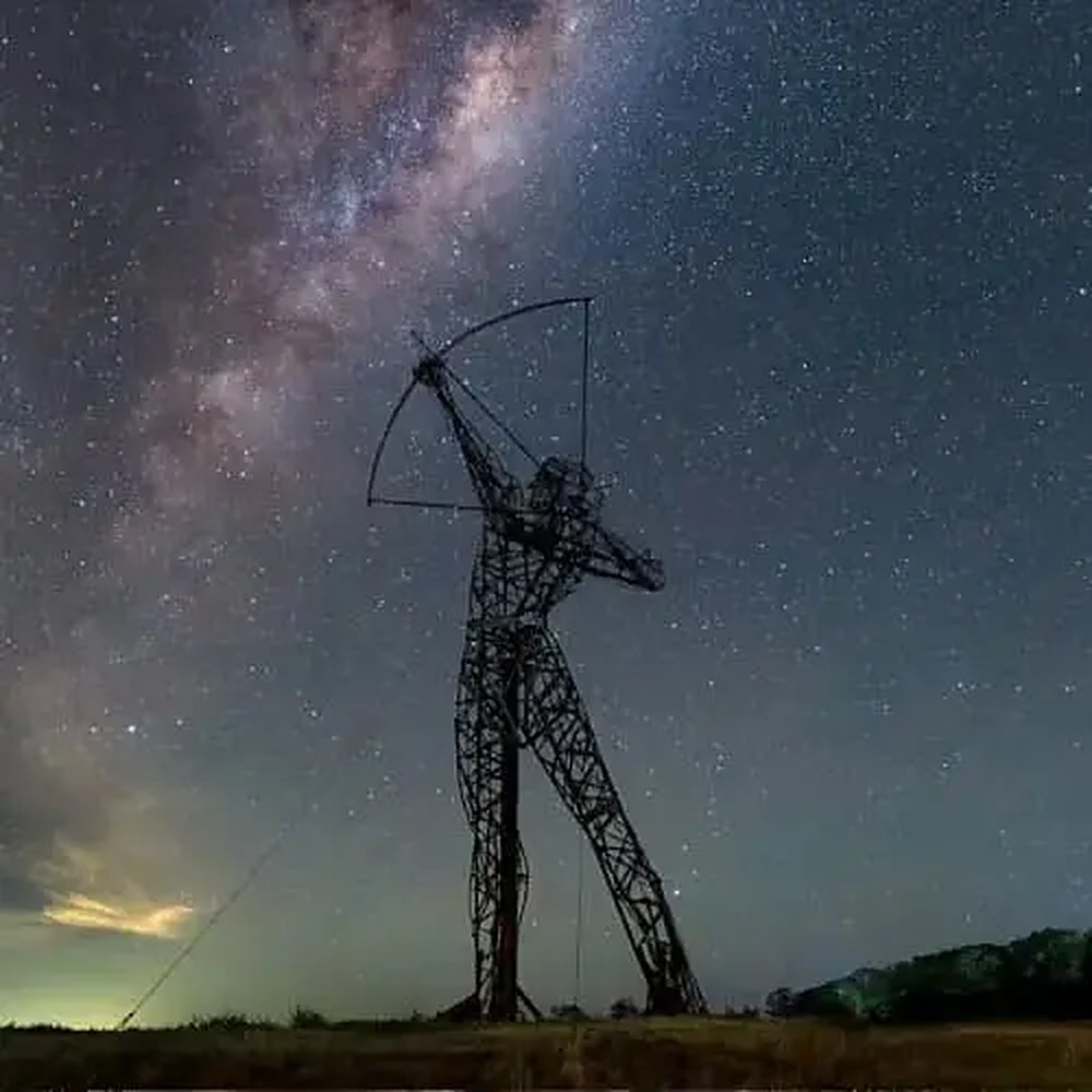 Escultura de un arquero de hierro bajo la Via Lactea
